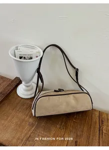 Minimalist suede bowling bag with brown contrast piping and slim shoulder strap