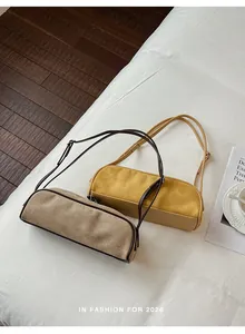 Suede bowling baguette bags in beige and yellow with brown straps.