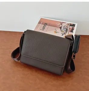 Vista detallada de un bolso de hombro marrón texturizado con un estuche lateral a juego.
