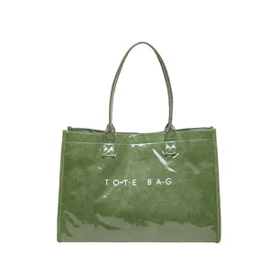 Vista detallada de un bolso tote de PVC verde con el texto blanco TOTE BAG impreso