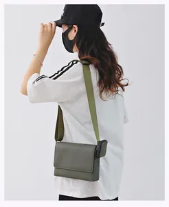 Vista lateral detallada de un pequeño bolso bandolera cuadrado verde militar en modelo.