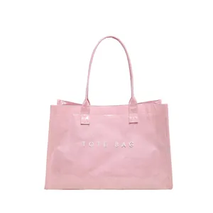 Vista frontal de un elegante bolso tote de PVC rosa con letras blancas TOTE BAG