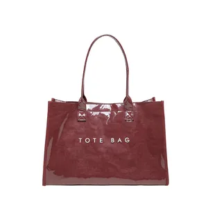 Detalle del bolso tote de PVC brillante burdeos con estampado TOTE BAG frontal