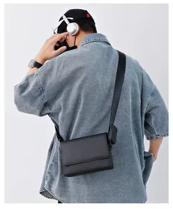 Vista trasera de un bolso bandolera negro minimalista con solapa de fibra carbono