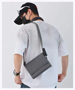 Vista trasera detallada de un bolso bandolera gris con una pequeña bolsa extraíble
