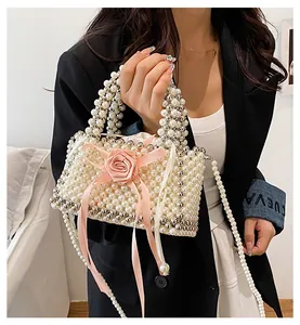Dettaglio borsa a mano in perle fatta a mano con rosa rosa e nastri decorativi
