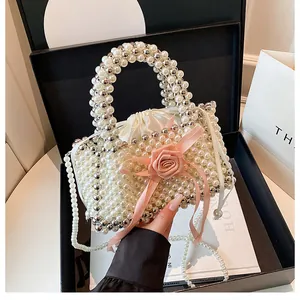 Primo piano della borsa in perle intrecciate con un elegante nastro a rosa rosa