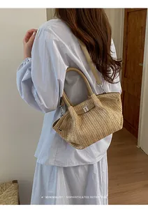 Bolso de paja trenzada con estilo retro lucido por una modelo con vestido azul claro