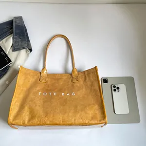 Vista detallada de un bolso tote de PVC amarillo transparente con texto TOTE BAG