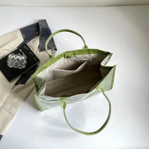 Vista interior detallada de un bolso tote de PVC transparente verde con bolsillos