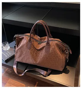 Stylish brown leopard print travel duffel bag with top handles and shoulder strap.