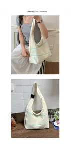 Cream canvas hobo bag for women with stylish mint green zipper details in a lifestyle setting