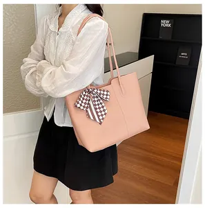 Gedetailleerd overzicht van roze minimalistische shopper met zijden sjaal op model.