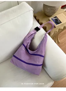 Detailed view of a light purple nylon shoulder bag with stylish multi-zipper compartments