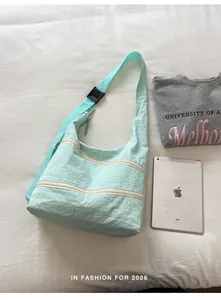 Mint green minimalist nylon crossbody bag shown with tablet and sweatshirt
