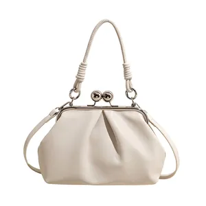 Detailed view of cream pleated cloud handbag with elegant silver metal ball clasp