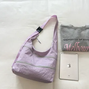 Lavender multi-zipper nylon crossbody bag on a white minimalist background