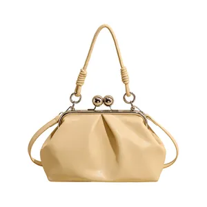 Creamy yellow cloud handbag with elegant pleated design and kiss-lock closure detail