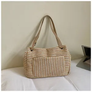 Bolso tote de paja tejida a rayas con correas de cuero para un look veraniego chic.