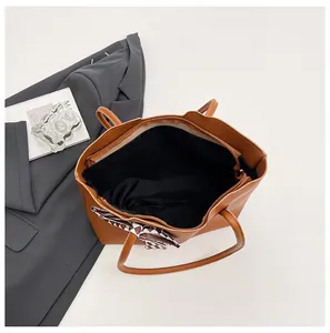 Gedetailleerd binnenaanzicht van een grote bruine shopper met een zijden sjaal luxe.
