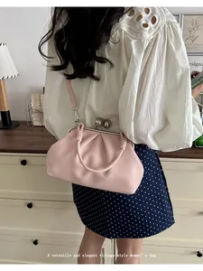 Elegant pink pleated cloud handbag with vintage kiss-lock closure shown on model