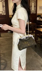 Detalle de bolso chino vintage con correa de perlas y elegante encaje