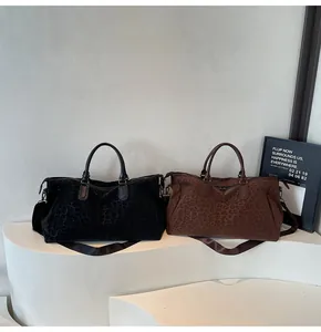 Black and brown leopard print travel bags displayed on a minimalist white platform