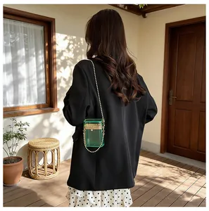 Elegant green transparent acrylic box bag featuring gold chain strap shown on model