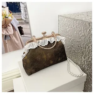 Primer plano de bolso vintage con encaje blanco y cierre de clip dorado metálico