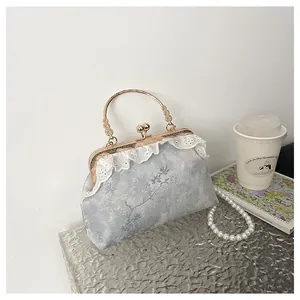 Vista detallada de un bolso vintage de estilo chino con encaje y correa de perlas