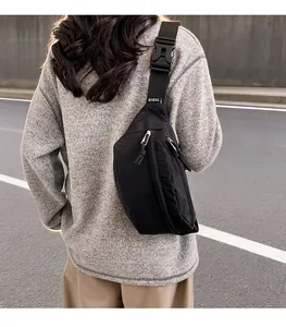 Close-up detail of a minimalist black lightweight chest bag styled as a back crossbody