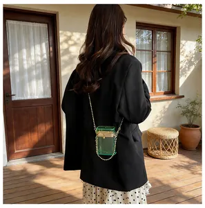Model showcasing a trendy transparent green acrylic box bag with gold chain strap