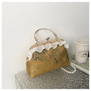 Detalle de bolso estilo chino con ribete de encaje y elegante correa de perlas cruzada.