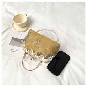 Bolso vintage de estilo chino con asa de perlas y detalles de encaje blanco delicados.
