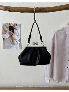 Detailed view of an elegant black pleated cloud handbag featuring a vintage clip closure