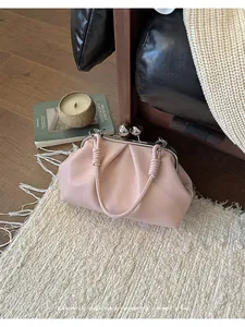 Close-up of a pink pleated cloud clutch bag with a vintage kiss-clasp closure