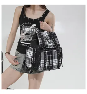 Detailansicht eines schicken karierten Rucksacks mit Nieten und einem Metallkreuz.