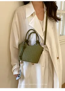 Detailansicht einer grünen gewebten Eimertasche am Model im raffinierten Retro-Stil