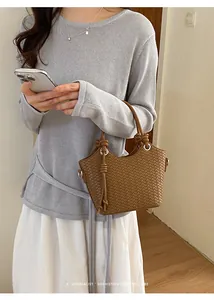 Detailansicht einer minimalistischen braunen Flecht-Beuteltasche mit Knotengriffen