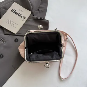 Elegant pink pleated cloud clasp handbag with open black interior and shoulder strap