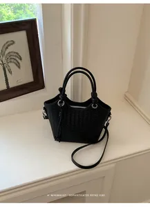 Minimalistische schwarze gewebte Beuteltasche auf einer hellen, sauberen Fensterbank.