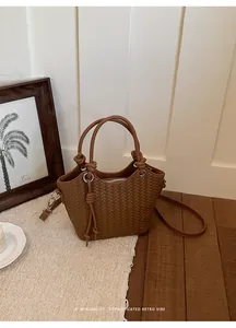 Detailaufnahme einer braunen geflochtenen Beuteltasche mit minimalistischem Retro-Vibe.