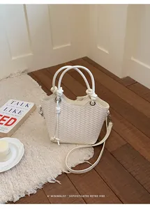 Detailansicht einer weißen gewebten Eimertasche in minimalistischem Ambiente