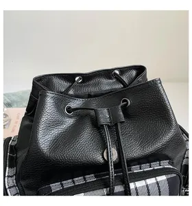 Detailansicht der Ledertextur und des Karomusters dieses modischen Damen-Rucksacks.