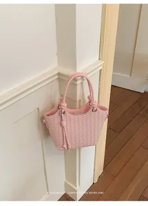 Detail eines rosa geflochtenen Eimerbeutels mit minimalistischem und retro-Vibe-Design