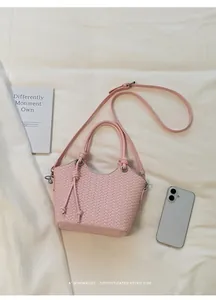 Detailansicht der rosa gewebten Beuteltasche mit Smartphone als Größenreferenz