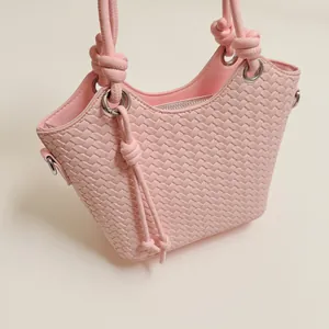 Bolso cubo rosa trenzado elegante con correas anudadas de moda y diseño espacioso.