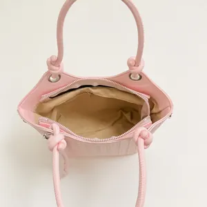 Elegante bolso bombonera tejido rosa con asas de nudo e interior con cremallera segura