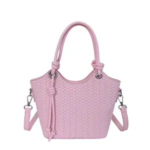 Elegante bolso bombonera de tejido rosa con asa superior y correa ajustable