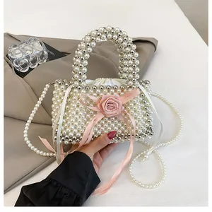 Vista dettagliata di una borsa a secchiello in perle fatta a mano con un fiocco a rosa rosa.